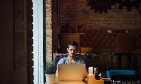 a person sitting at a table in front of a building
