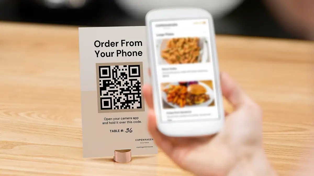 A person scans a QR code using a mobile device to browse online ordering menus.