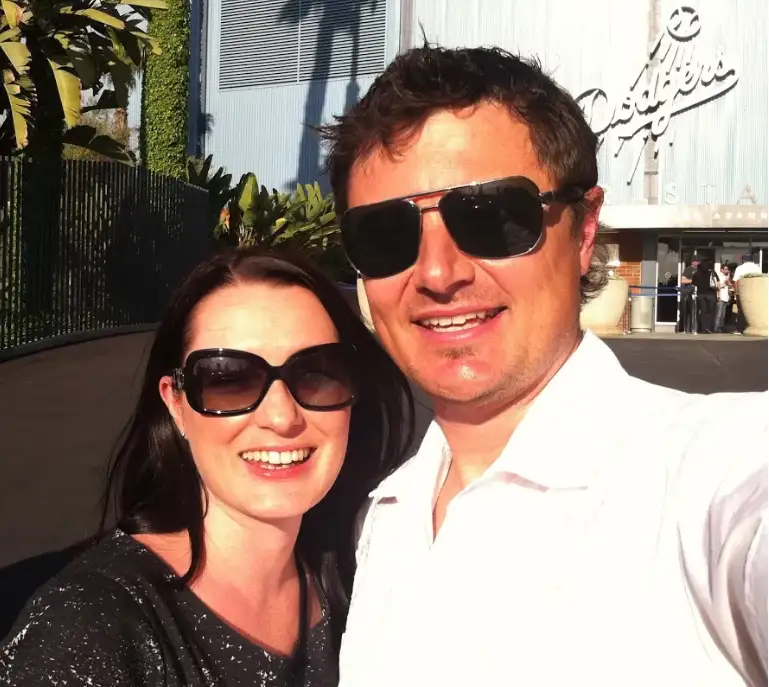 a man and a woman wearing sunglasses posing for the camera
