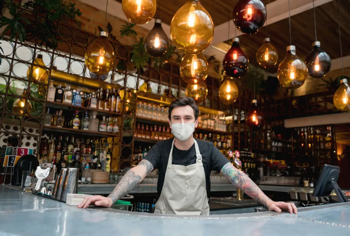 A bartender at a restaurant wearing a mask COVID-19