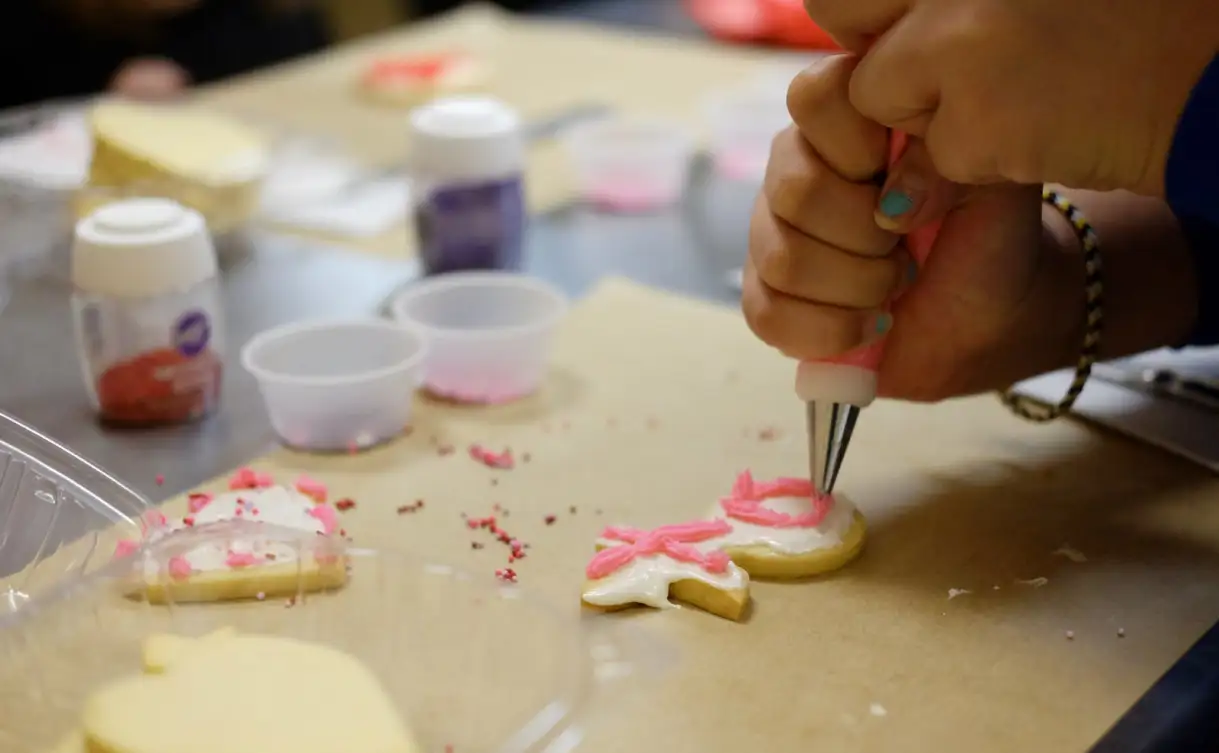 Young girl decorating cookies at Café Du Pain's class