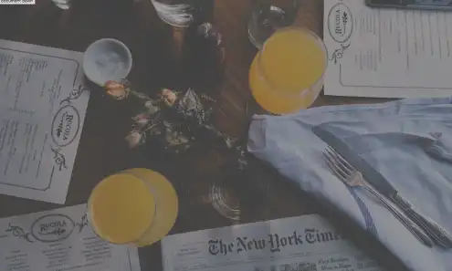 Restaurant menus, drinks and a newspaper on a table.