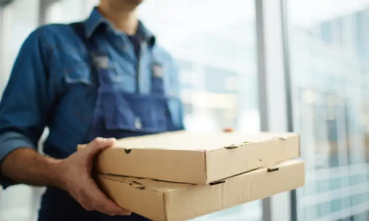 A restaurant worker with delivery boxes