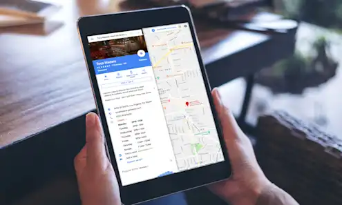 a hand holding a laptop