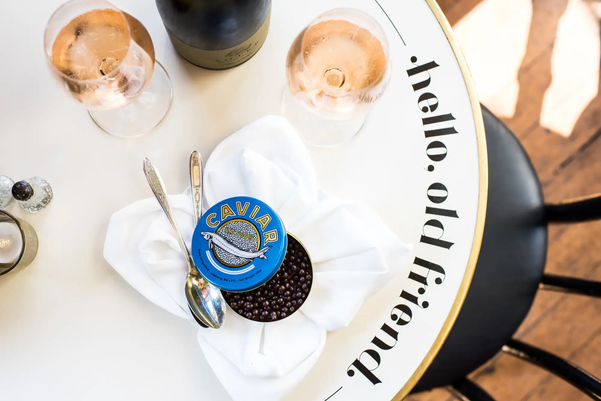 a glass of wine and caviar on a table