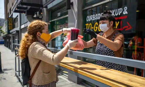 A woman picking up food at a restaurant during COVID-19