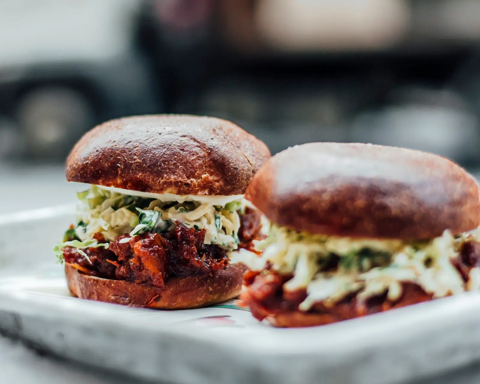 a close up of two burgers on a plate