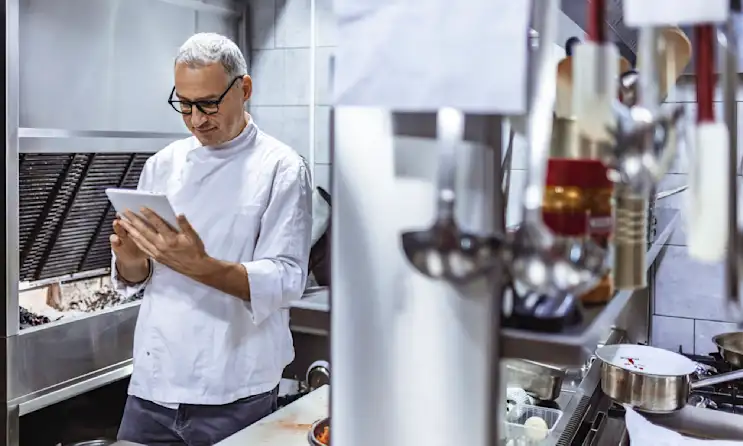 a man standing in a kitchen preparing food