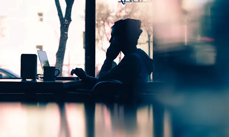 A person sitting at a cafe on their laptop looking at a restaurant website.
