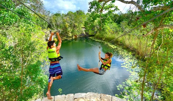 Young boy and girl ziplining over lagoon