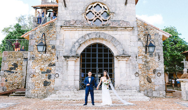 Bride and groom posing in front of an old church