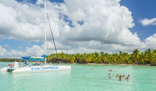 Groupe de vacanciers nageant le long d’un catamaran