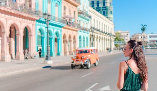 Woman walking by colourful buildings in Havana