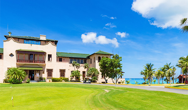 Colonial-style golf club with the ocean in the distance