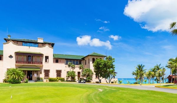 Parcours de golf de style colonial, avec l'océan à l'horizon