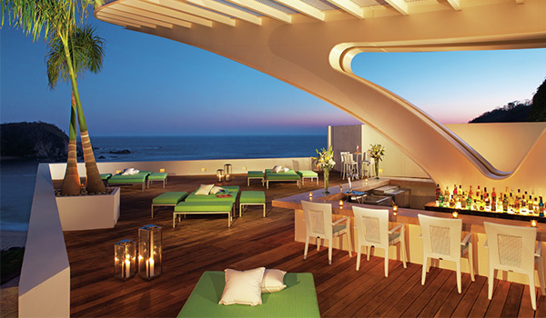 Rooftop bar overlooking the ocean at sunset