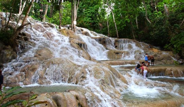 People climbing the rushing cascades of Dunn's River Falls