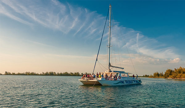 Catamaran cruising along the coast of Cayo Largo at sunset