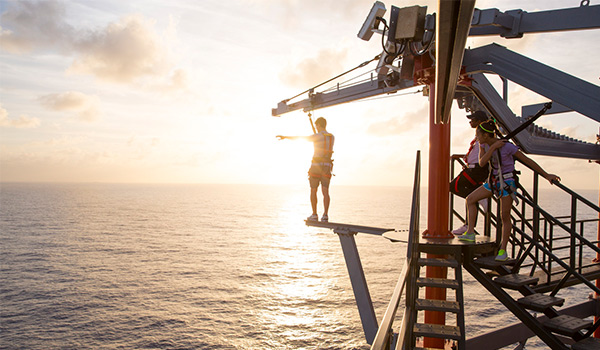 Person walking on a plank over the ocean from a cruise ship deck