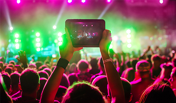 Femme enregistrant un spectacle sur iPad au Reggae Sumfest