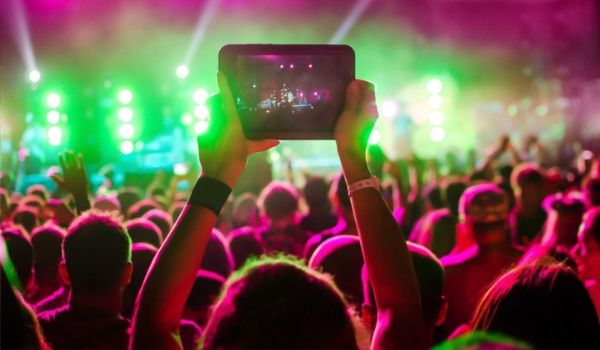 Woman recording performance on iPad at Reggae Sumfest