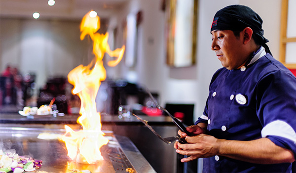 Chef cooking over a Teppanyaki stove