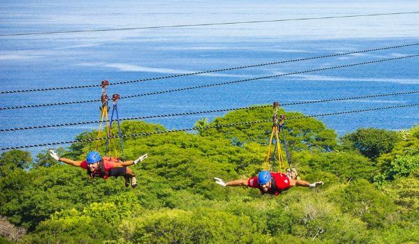 Deux personnes glissant en tandem sur une tyrolienne dans la jungle