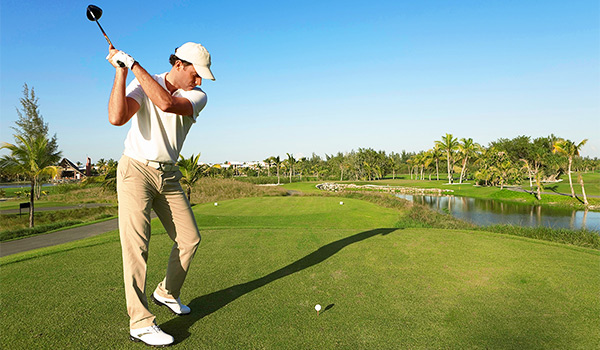 Golfeur se préparant à frapper une balle sur un splendide parcours de golf