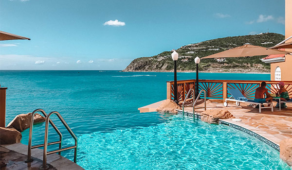 Infinity pool overlooking the breathtaking coast of St Maarten with hills in the background