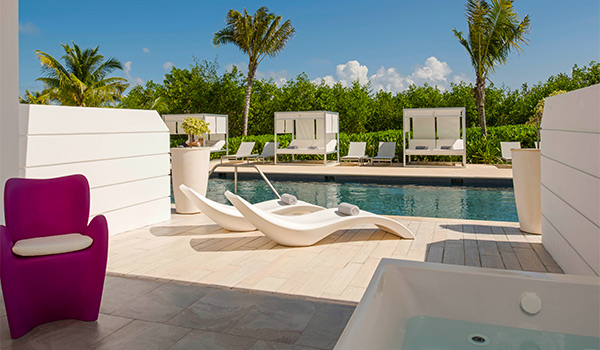 Pool lined with sun loungers overlooking the sea