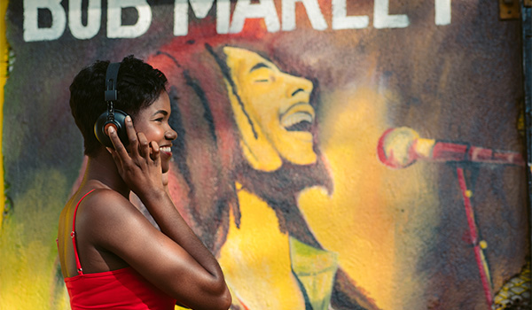 Woman standing in front of a Bob Marley mural