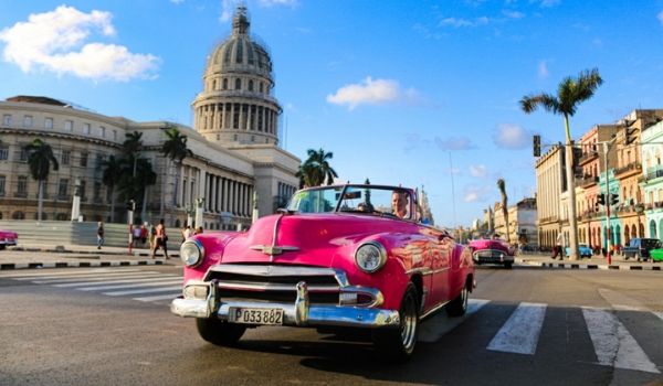 Classic car riding through the streets of Havana
