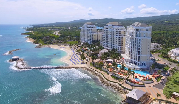 Aerial view of a hotel overlooking the beach with mountains in the background