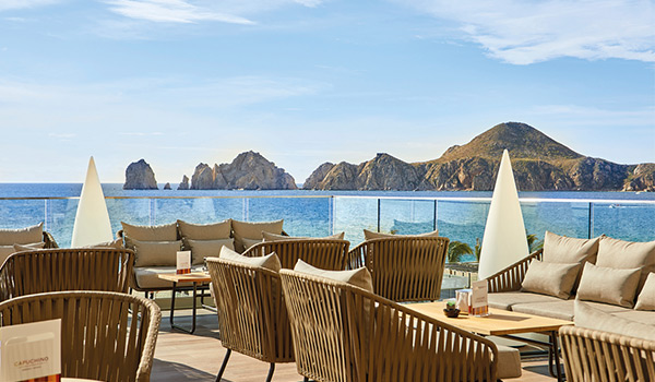 Terrasse d’un café dotée de chaises confortables et donnant sur les arches rocheuses de Los Cabos