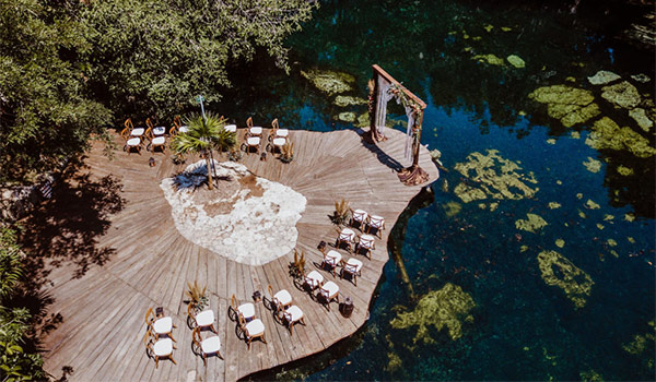 Aerial view of a wedding ceremony on a deck overlooking a cenote