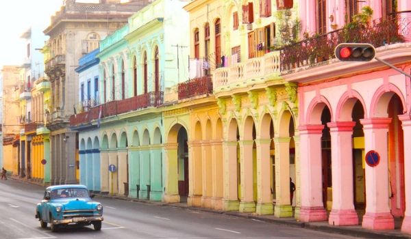 Classic American drive driving past colourful buildings