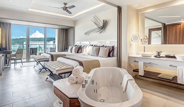 Chambre spacieuse avec deux lits et un jacuzzi donnant sur la mer