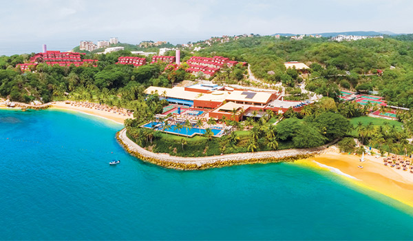 Aerial shot of resort overlooking the ocean with two golden-sand beaches