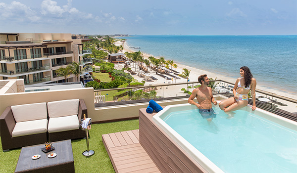 Couple dans un jacuzzi sur un toit surplombant la mer