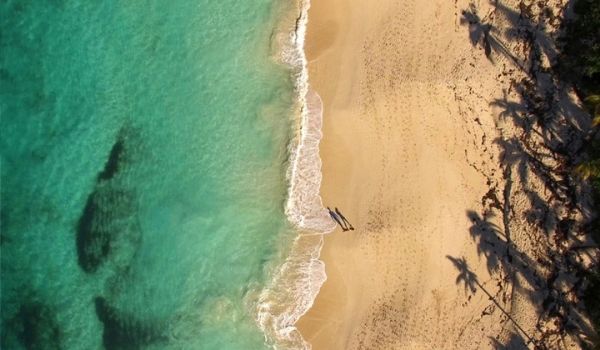 Aerial view of man and woman walking on Paradise Beach