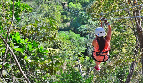 Femme faisant de la tyrolienne dans une jungle verdoyante au Costa Rica