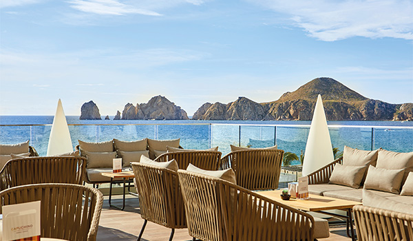Outdoor coffee shop with comfortable chairs overlooking the rocky coast of Los Cabos