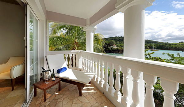 Lounge chair with a bottle of champagne on a balcony overlooking the ocean