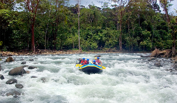 Raft full of people steering down white-water rapids
