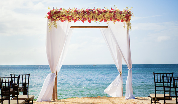 Wedding arch decorated in flowers on the beach