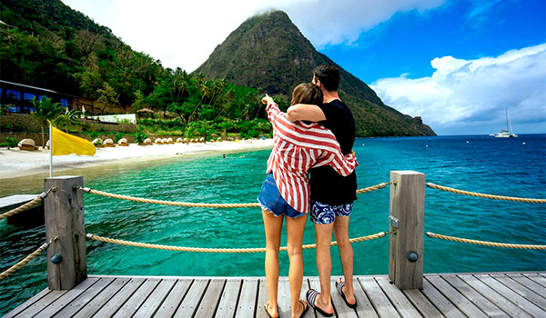 Couple debout sur un quai face aux Pitons