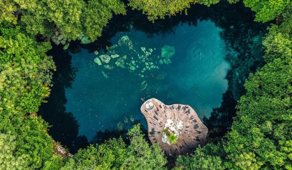 Aerial view of beautiful cenote surrounded by jungle