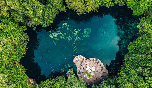 Aerial view of beautiful cenote surrounded by jungle