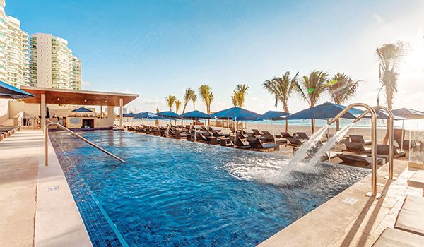 Piscine à côté de chaises longues sur la plage