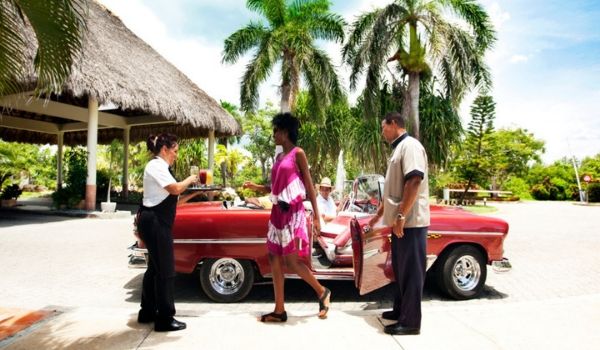 Couple descendant d'une voiture américaine classique à l'hôtel